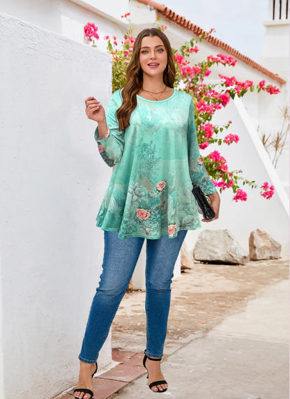 Woman wearing a floral mint green top and blue jeans standing in front of a white wall with pink flowers.