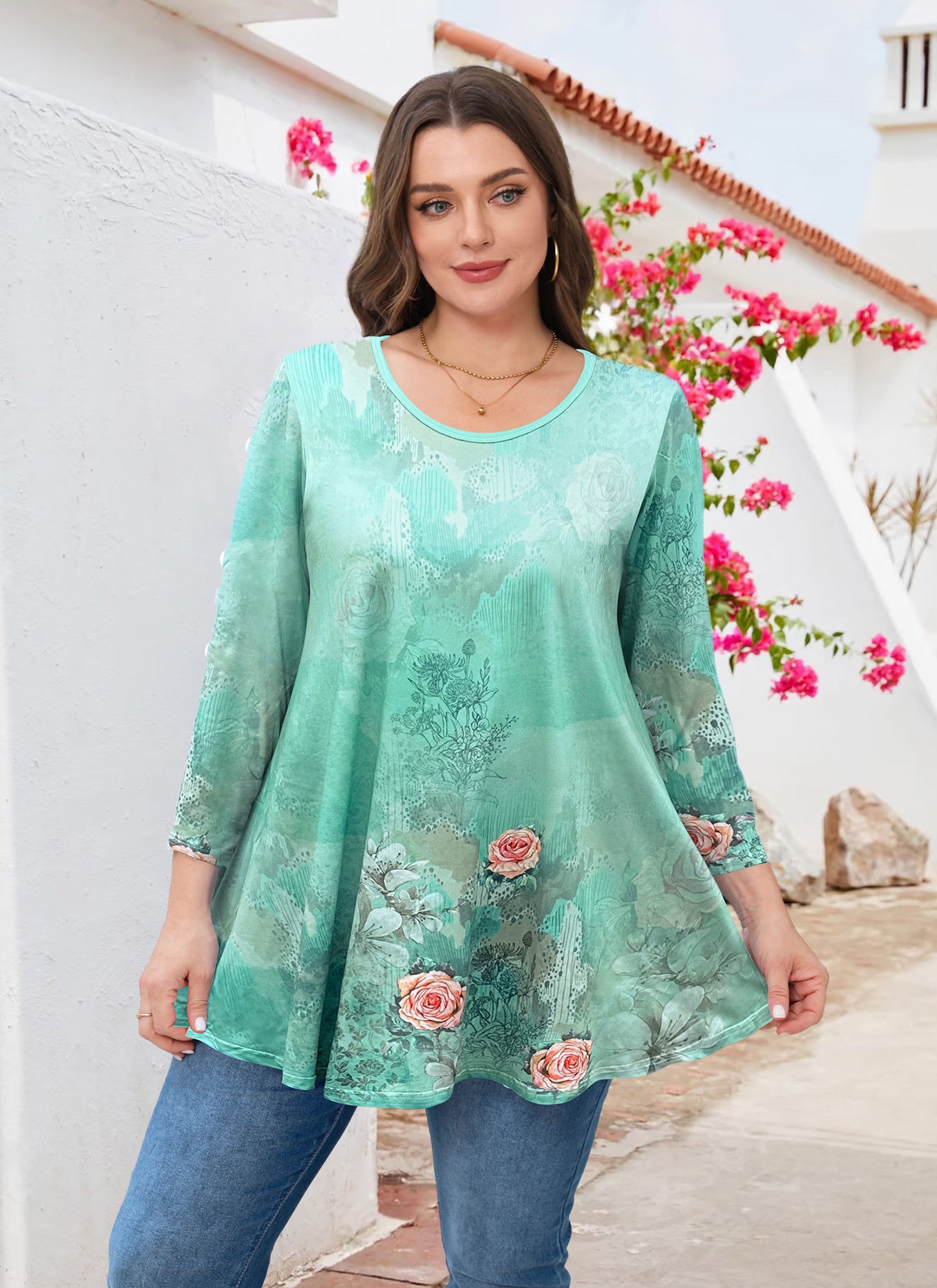 Woman wearing a teal floral blouse with blue jeans in a garden setting
