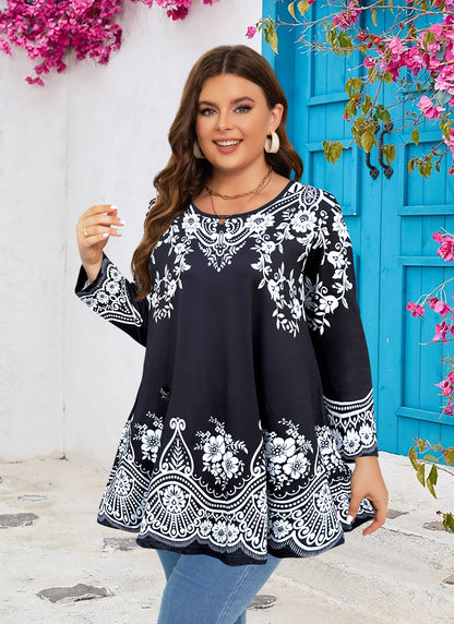 Woman wearing a black blouse with white floral patterns in front of a blue door and pink flowers.